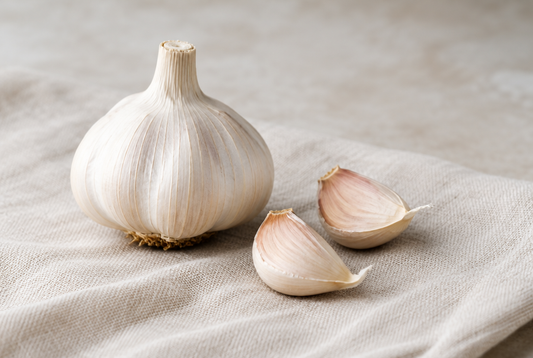 A garlic bulb beside two separated cloves