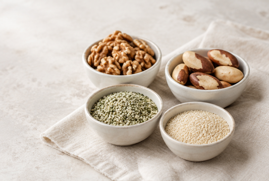 Four bowls of walnuts, Brazil nuts, hemp seeds and sesame seeds