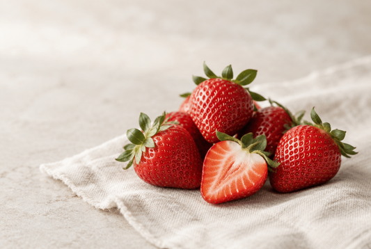 Fresh strawberries with their green calyx, one cut in half